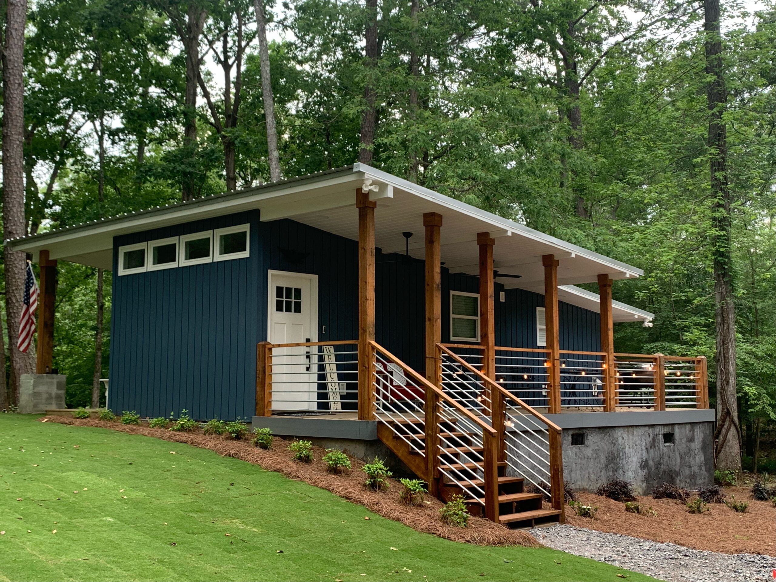 Front view of the Camp Holloway house with a staircase and a wrap around deck.